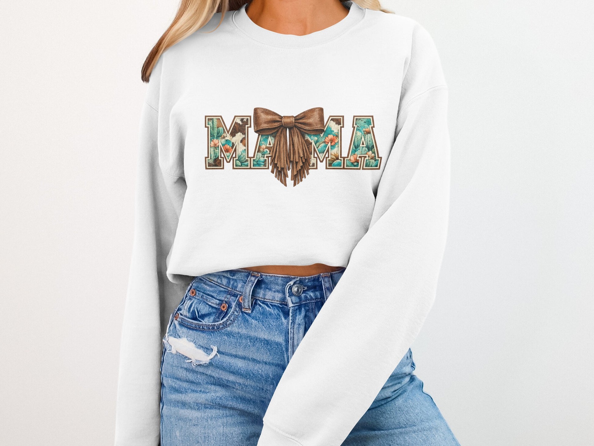 White sweatshirt with "MAMA" in floral and cactus print with a brown bow.