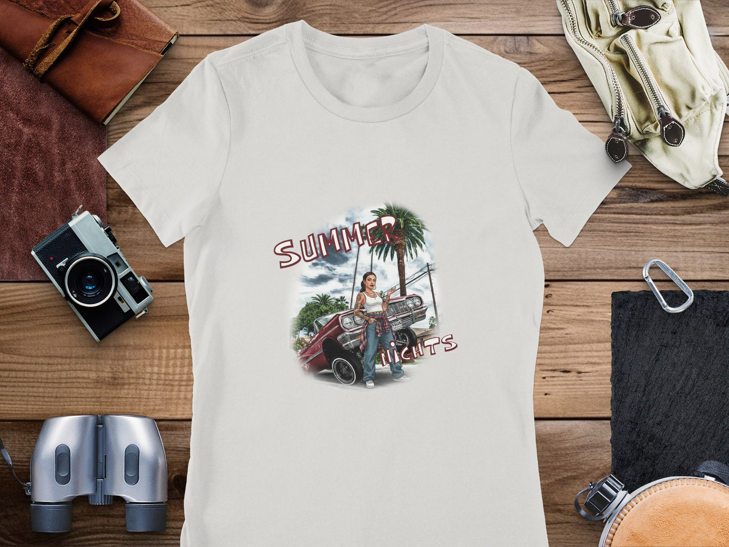 T-shirt graphic of woman with lowrider car and palm tree, "Summer Nights" text.
